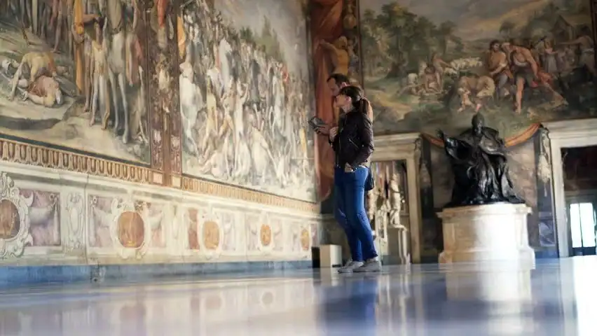 Dimly lit vatican gallery with a couple admiring artwork