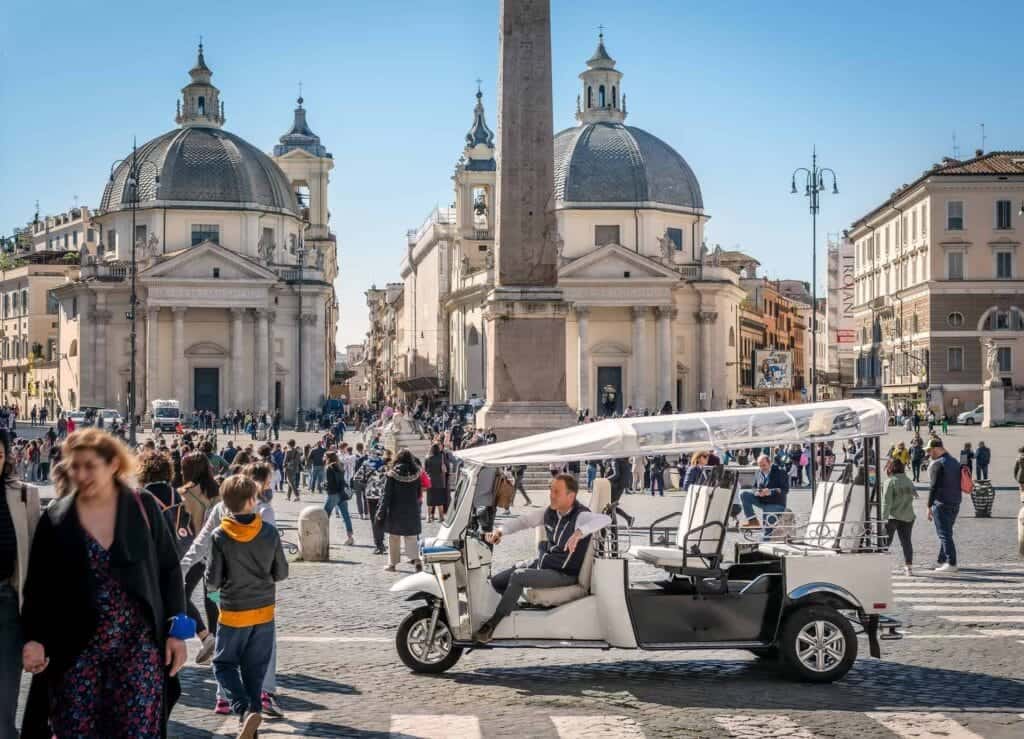 Family riding a golf cart past the colosseum
